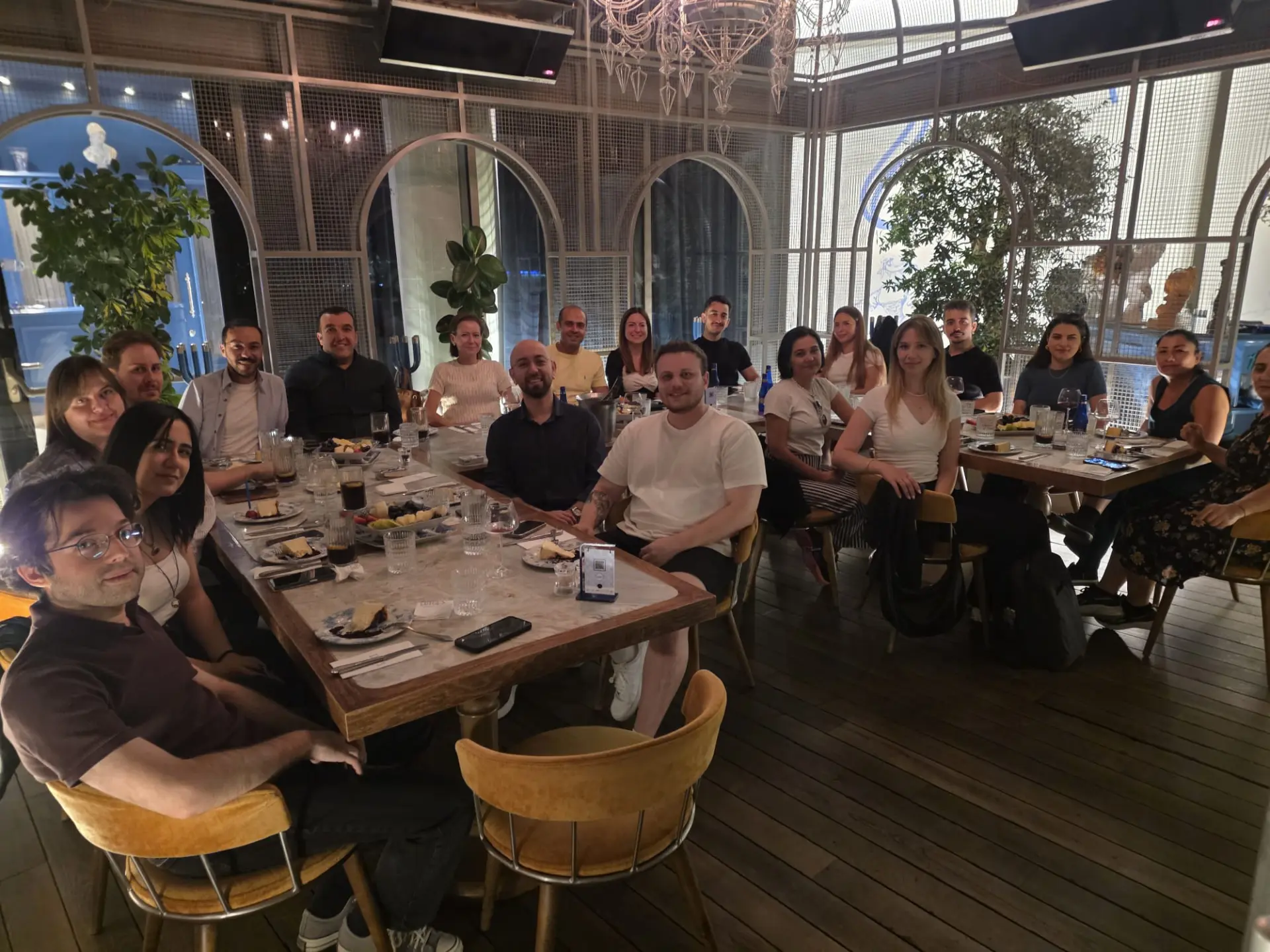 The Devin Tech team gathered around a long dinner table, smiling at the camera