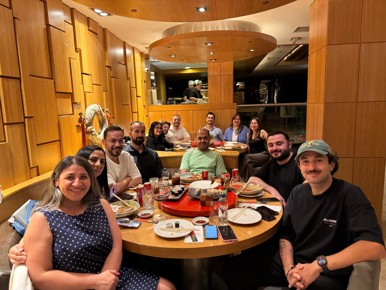 Devin Tech colleagues sharing a relaxed dinner at a round restaurant table